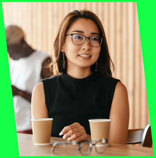 Woman in glasses talking over coffee at a table